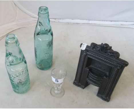 A miniature fireplace and two glass bottles