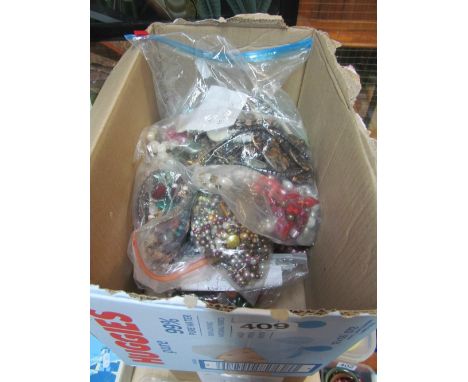 A cardboard box with bagged gemstone and pearl necklaces