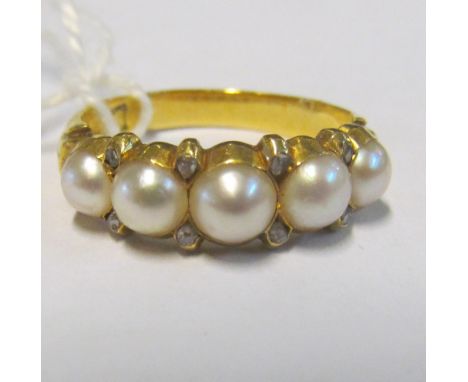 A five stone pearl and diamond chip ring on 18ct gold band