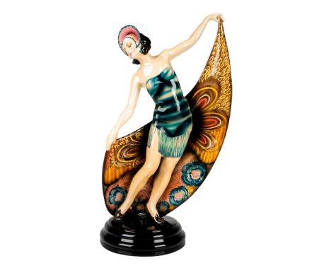 Art Deco figure of a dancer in a headdress and a short and strapless dress. She is holding a large scarf with elaborated flor