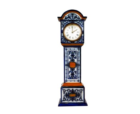 A very rare novelty piece modeled as a longcase clock decorated in blue and brown raised pattern, white enamel dial with blac