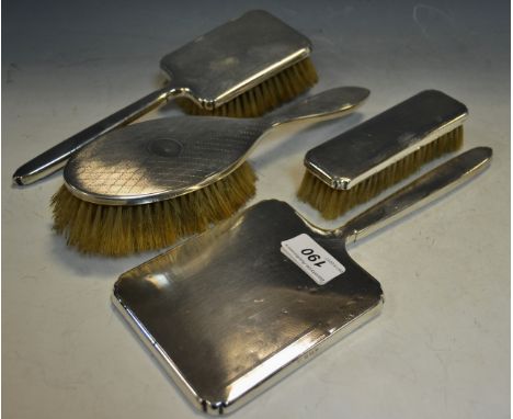 A silver backed engine turned hand mirror, Birmingham 1939, a conforming hairbrush and clothes brush ; a silver backed hairbr
