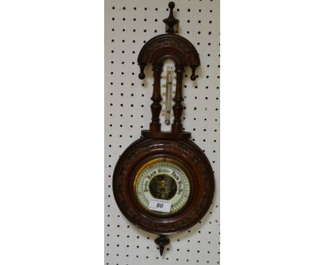 A 19th century carved mahogany aneroid barometer/thermometer arched top, turned finnials