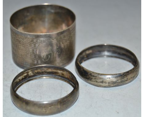 A silver engine turned napkin ring; a pair of silver napkin rings , 25.9g gross