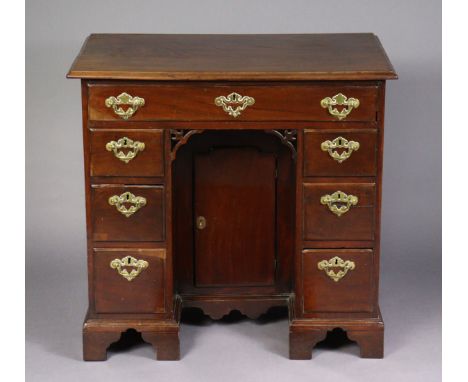 AN 18TH CENTURY MAHOGANY SMALL KNEEHOLE DESK, with moulded edge to the rectangular top, fitted an arrangement of seven drawer