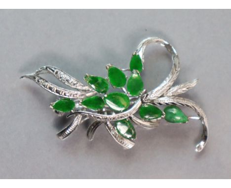 A 14K white leaf-spray brooch set ten green jade leaves; 5.3 cm long. (6.3 gm).