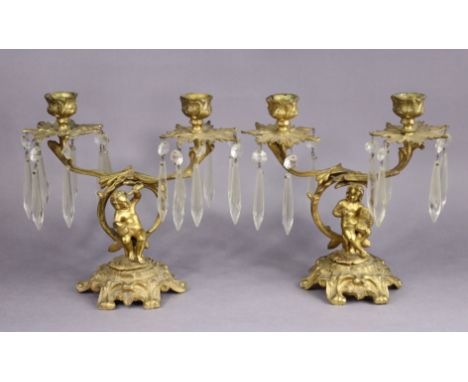 A pair of 19th century ormolu twin-branch candelabra with foliate sconces on figural supports &amp; rococo-style circular bas