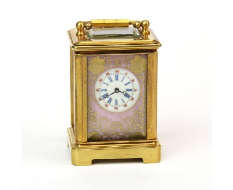 A miniature brass carriage clock with porcelain panels. H.7 cms.