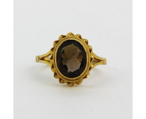 A hallmarked 9ct yellow gold ring set with an oval cut brown tourmaline, (K).