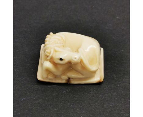 A carved fossilised mammoth tusk signed Netsuke of a horse.