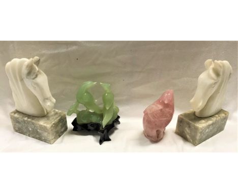 A pair of hard stone sculptures of horse's heads on marble bases, a hard stone sculpture of a cockerel and a jade carving of 