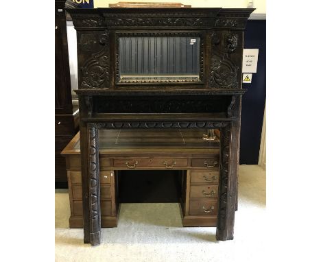 A Victorian Gothic Revival fire surround with mirrored upper section and lion mask ring ornamentation