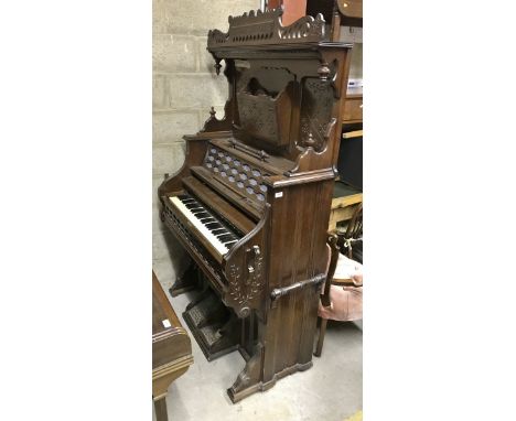 A late 19th Century American walnut cased pedal organ with candle stands, carrying handles, music compartment, etc (possibly 