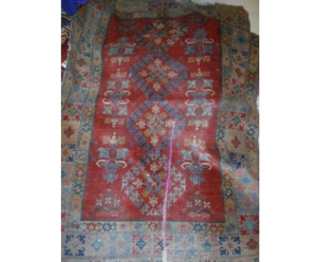 A Persian rug, the central panel set with floral motifs on a rust red ground within a stepped floral decorated border, a Keli
