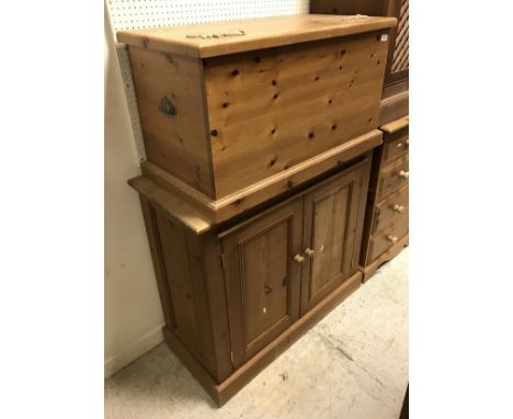 A modern pine trunk with oak leaf and acorn decoration and a pine two door kitchen cupboard and pine plate rack