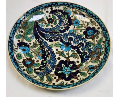 A Burmantofts faience charger, floral decorated in the Middle Eastern taste in blues, browns and greens by Leonard King, stam