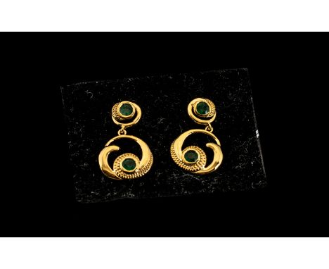 Emerald 'Wave and Circle' Drop Earrings, each earring comprising a deep green emerald set in a wave shape inside a circular d