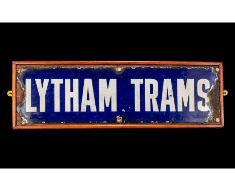 An Antique Enamel on Tin Lytham Trams Sign rough edges all around. Screwed to a modern back board. Measures 8 by 25 inches.