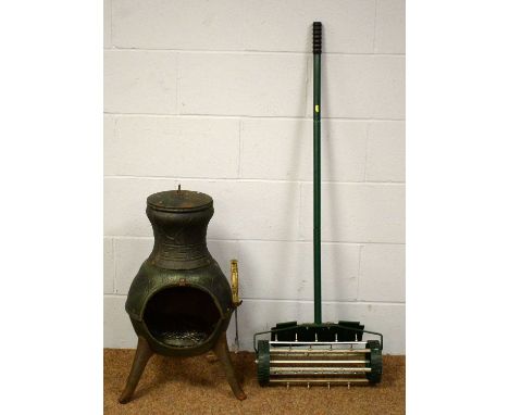 A 20th Century cast iron chiminea with lid and fire tool, together with a 20th Century lawn scarifier. (2)