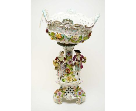 A late 19th Century ceramic Dresden figural and floral encrusted comport on stand, 48cms high overall. 