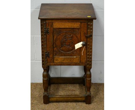 A 20th Century oak pot cupboard in the 17th Century style, the square top above a carved panelled door enclosing a single she