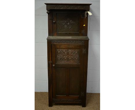 A 20th Century oak court cupboard of small proportions in the 17th Century style, the projecting foliated carved frieze above