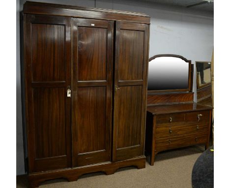 A 20th Century mahogany three door wardrobe, the caddy top above three panelled cupboard drawers enclosing drawers and pigeon