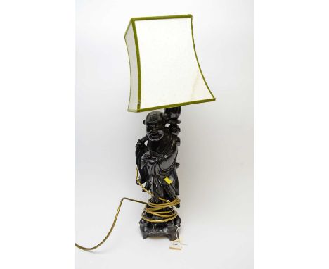 A Chinese hardwood figural table lamp, carved as a figure of a man, 48cms high excluding shade. 