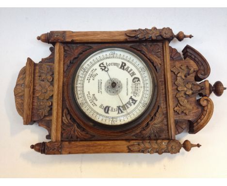 A carved oak framed barometer, the dial labelled Stoke & Watson Manchester. L48cm