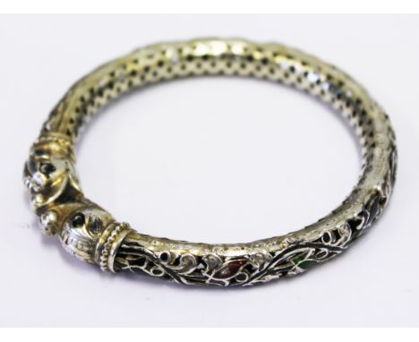 An eastern white metal and enamel bangle. Diam. 7cm