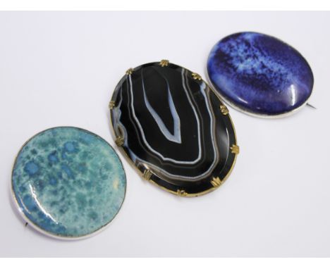 Two Ruskin style enamel and silver brooches and a metal mounted agate brooch