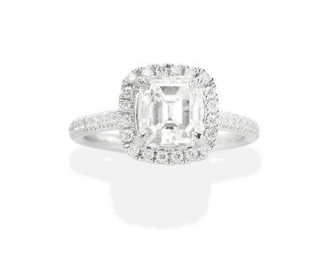DIAMOND RINGThe step-cut diamond, weighing 2.16 carats, within a brilliant-cut diamond halo surround, between similarly-cut d
