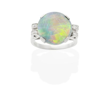 BLACK OPAL AND DIAMOND RINGThe double cabochon black opal between scrolling single-cut diamond shoulders,  ring size very app