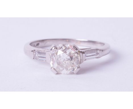 A platinum diamond solitaire ring, 1.21 carats, colour H, clarity SI 2, old cut, with baguette cut diamonds on the shoulders,