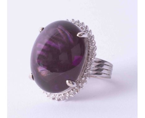A white metal cluster ring set large Amethyst cabochon surrounded by small diamonds, stamped YK10 and 45.0, finger size N.