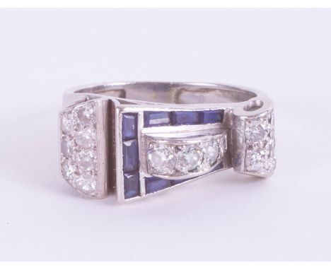 An Art Deco sapphire and diamond ring of Cartier style, size Q. In a sculptural asymmetric Art Deco design. The total weight 