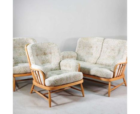 An Ercol Windsor light elm three piece suite, comprising a pair of armchairs and a sofa, with cream cushions (3)140w x 74d x 