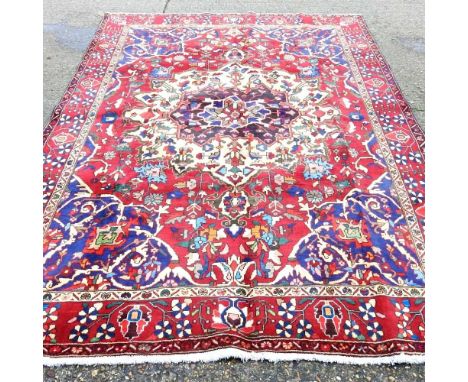 Persian Bakhtiari carpet, with an ivory coloured medallion, on a red ground, 314 x 214cm