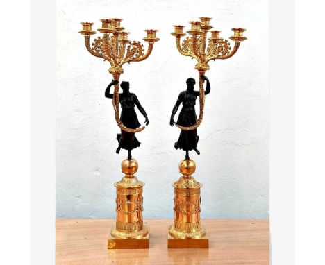 A pair of large Empire style gilt metal and bronze table candelabra, 20th century, each modelled as a standing figure holding