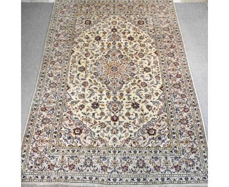 A Persian Kashan carpet, with all over foliate designs, on an ivory coloured ground, 355 x 250cmOverall condition is good, wo