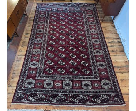 A Persian carpet, having a field of medallions on a red ground, within multiple borders, 390 x 250cm