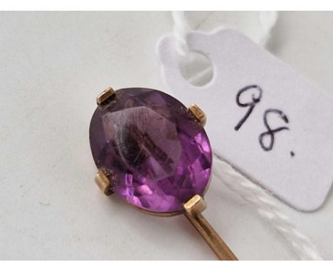 A gold and amethyst stick pin
