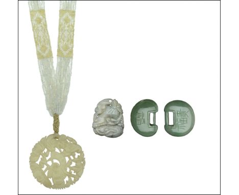 A collection of green hardstone items, including two kidney-shaped discs, a circular pendant with pierced decoration of a bir