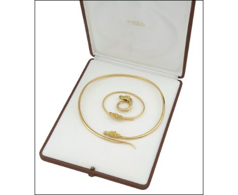 A gold and gem-set horse head suite, by FRED, comprising a torque necklace, bangle and ring, each of wrap around design with 