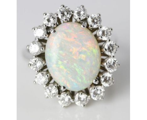 Damenring. 18 kt. WG, geprüft, brutto 6,7 g. Besetzt mit ovalem, weißen Opalcabochon, umgeben von Kranz aus 16 Brillanten,  z
