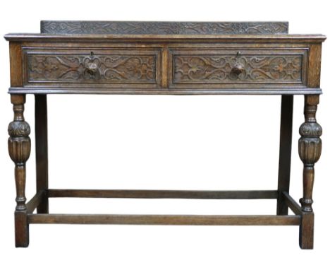 An early 20th century oak two drawer buffet table on turned supports joined by stretchers, 92cm high x 122cm wide x 50cm deep