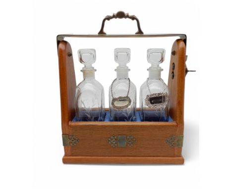 A three bottle tantalus with brass mounts Condition Report:Available upon request