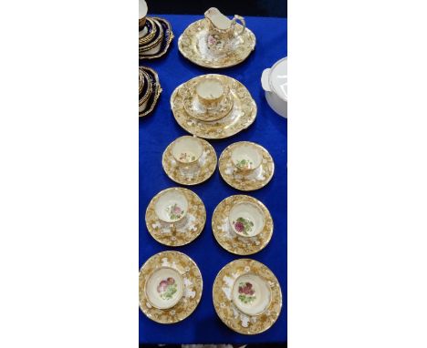 A Victorian tea set, the puce and gilt ground painted with a floral study to the centre of the saucer and the cup, comprising