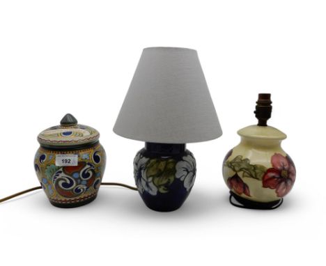 A Moorcroft lamp in Clematis pattern, another in Hibiscus pattern together with a Gouda tobacco jar and cover Condition Repor