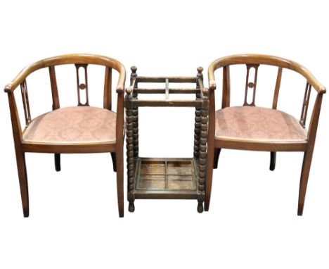 A lot comprising a pair of early 20th century mahogany horseshoe back parlour armchairs and an oak bobbin umbrella stand (3) 